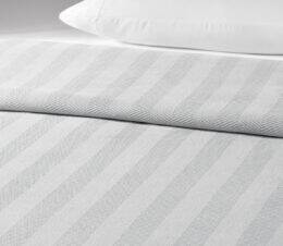 The Chenille Herringbone bedspread is shown here on a bed in the Lunar colorway.
