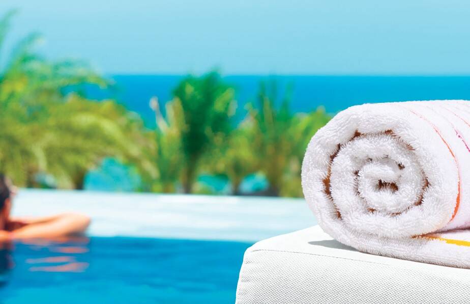 luxury pool towel rolled up on a lounge chair.