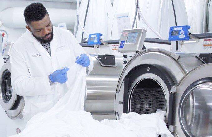 Laundry technician examining sheets for damage